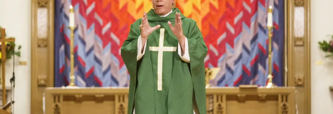 Bishop Andrew Asbil speaks at the front of a church