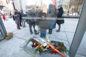 Flowers lie in the streetcar shelter where a man died on Jan. 6. Photos by Michael Hudson