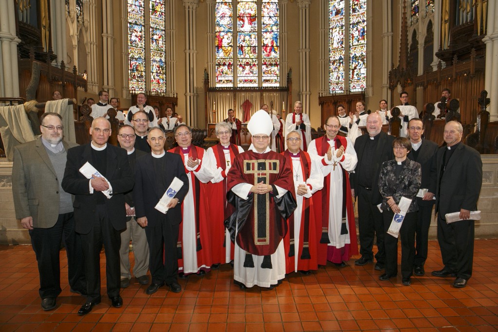 Clergy receive their Silver Jubilee stoles from Archbishop Johnson.