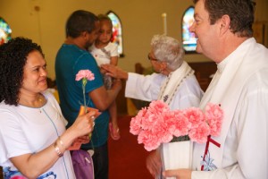 The Rev. Mark Gladding gives out carnations after the Mother's Day service at St. Margaret, New Toronto. Photo by Michael Hudson
