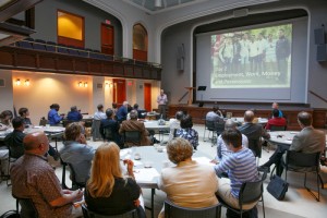 Those attending the symposium watch a presentation.