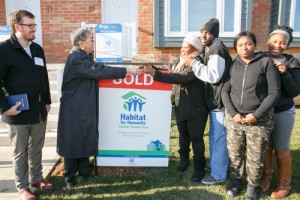 Bishop Patrick Yu hands Marianne Romain and her family the keys to their new home. 