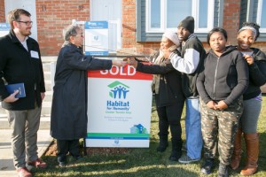 Bishop Patrick Yu hands Marianne Romain and her family the keys to their new home.