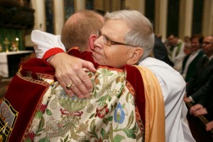 Bishop Walter Asbil gives his son a hug. Photo by Michael Hudson