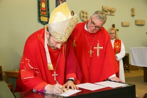 Bishop Philip Poole and Bishop Michael Pryse of the Evangelical Lutheran Church in Canada sign the agreement to merge Holy Spirit and Peace Lutheran in to Holy Spirit of Peace. 