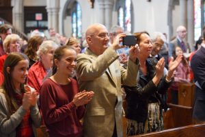 Parishioners applaud the Brimo family after their baptism. 