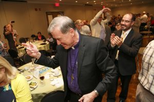 Archbishop Hiltz joins in the dancing to "When the Saints Go Marching In."