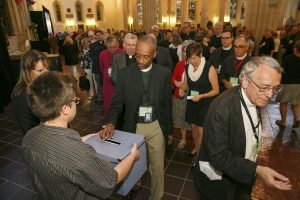 Clergy form a line to put their paper ballots into the ballot box.