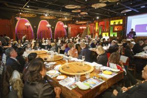 Many people sit at dinner tables in a Chinese restaurant.