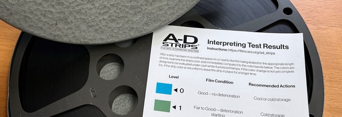 Image showing lid of film canister with title of film, along with 16 mm film reel and bright yellow A-D test strip and result key showing critical deterioration.